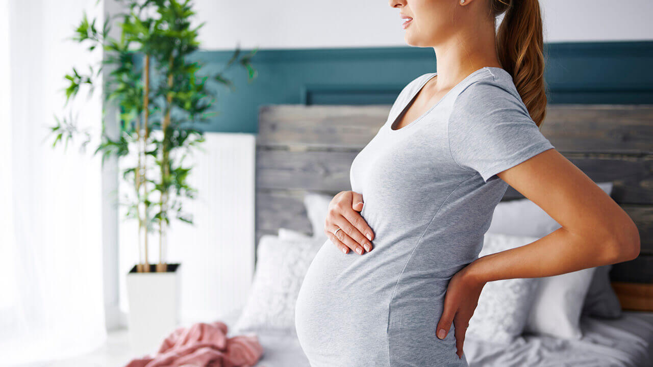 pregnant woman with hand on her stomach and back