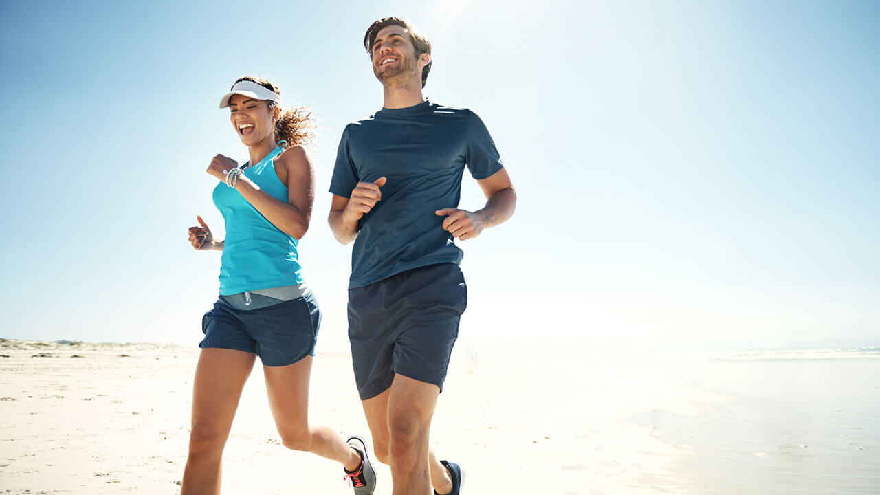 Young male and woman running side by side