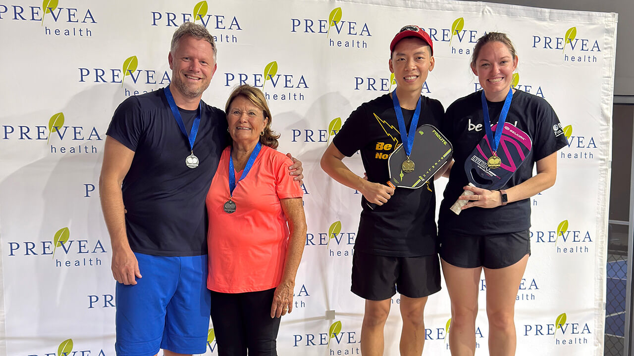 A group of people holding pickleball paddles