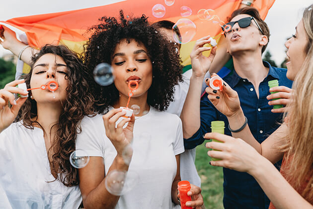 A diverse group of teenagers blow bubbles