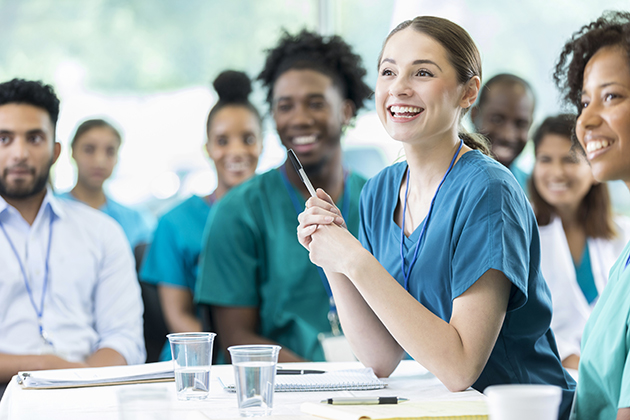 Nurses sit at a table during a meeting
