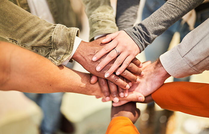group of professionals putting their hands in a circle
