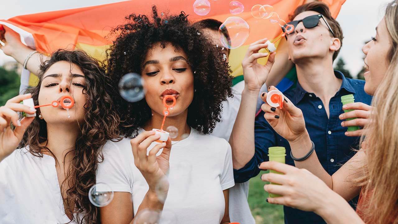 A diverse group of teenagers blow bubbles