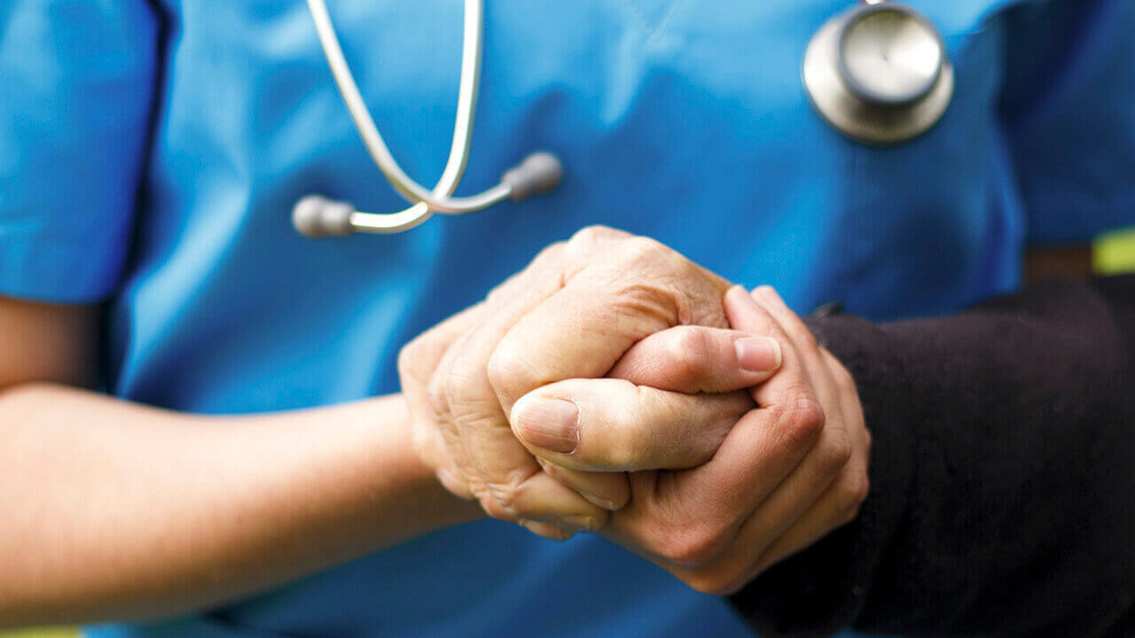 Nurse holding patient hand