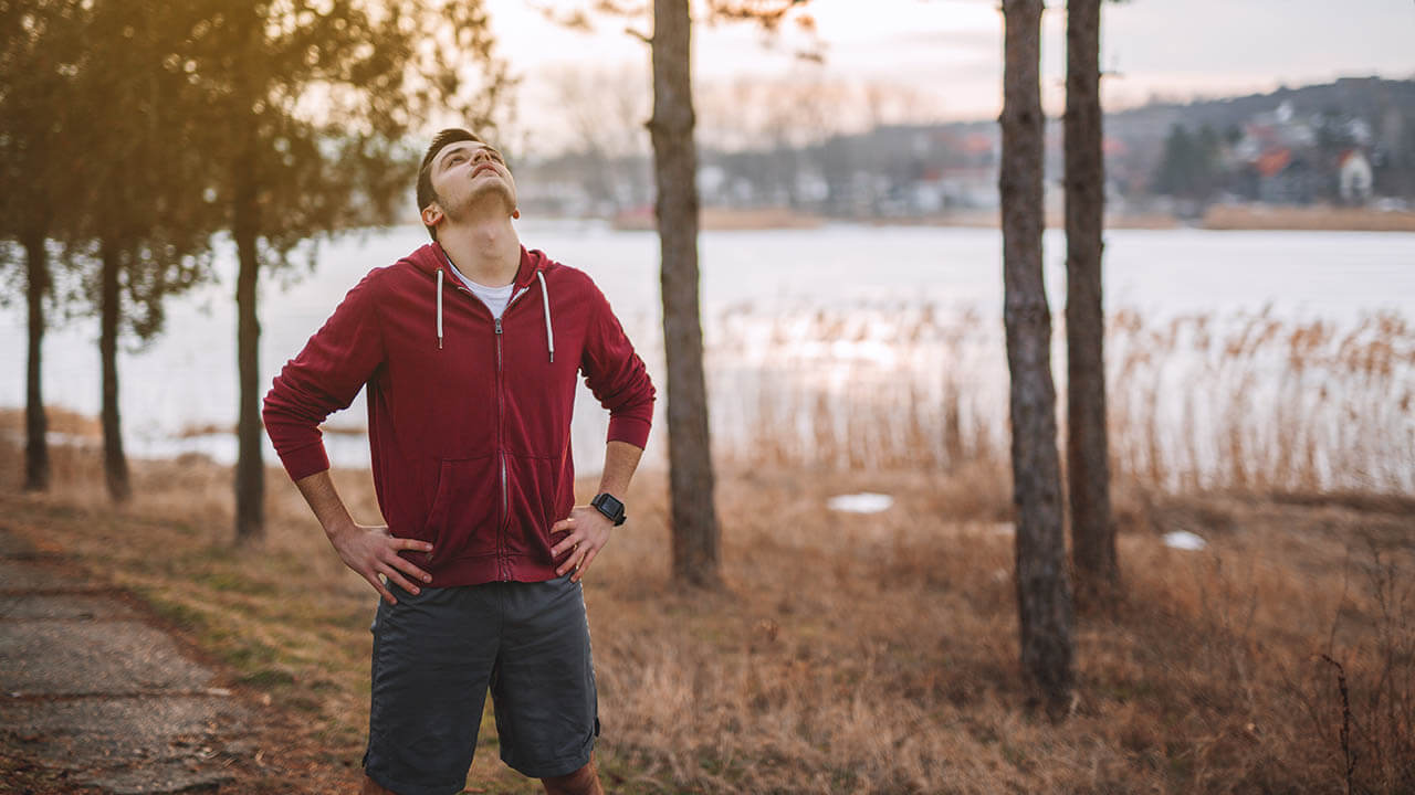 Young male looking at the sky in the woods