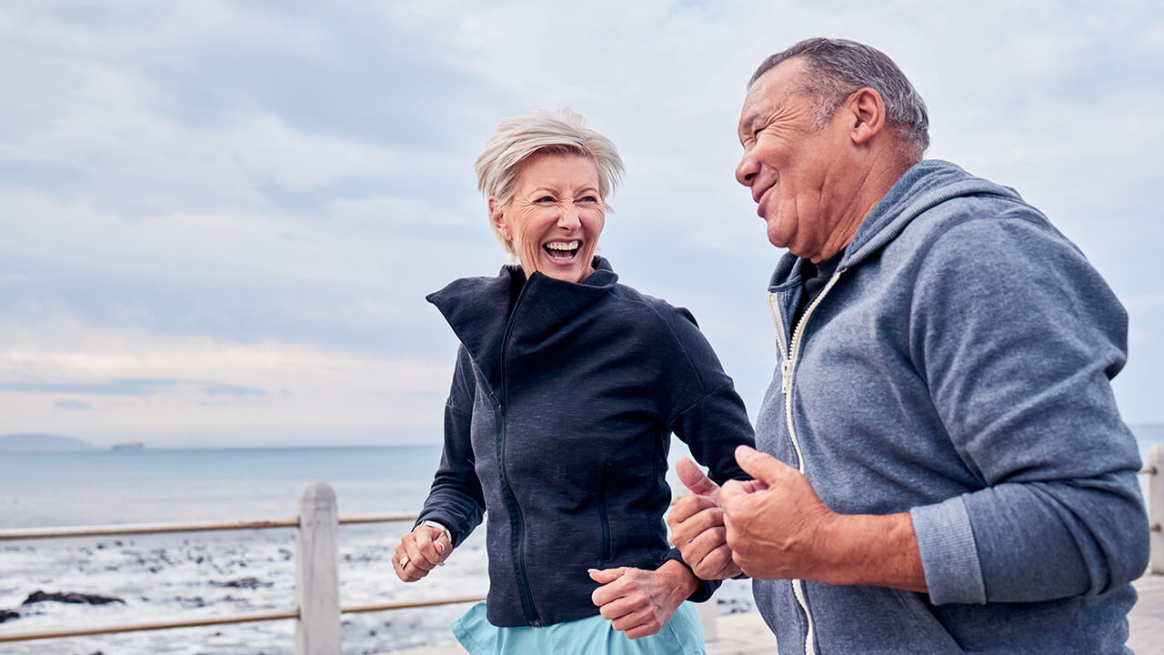 Middle aged couple running on a beach
