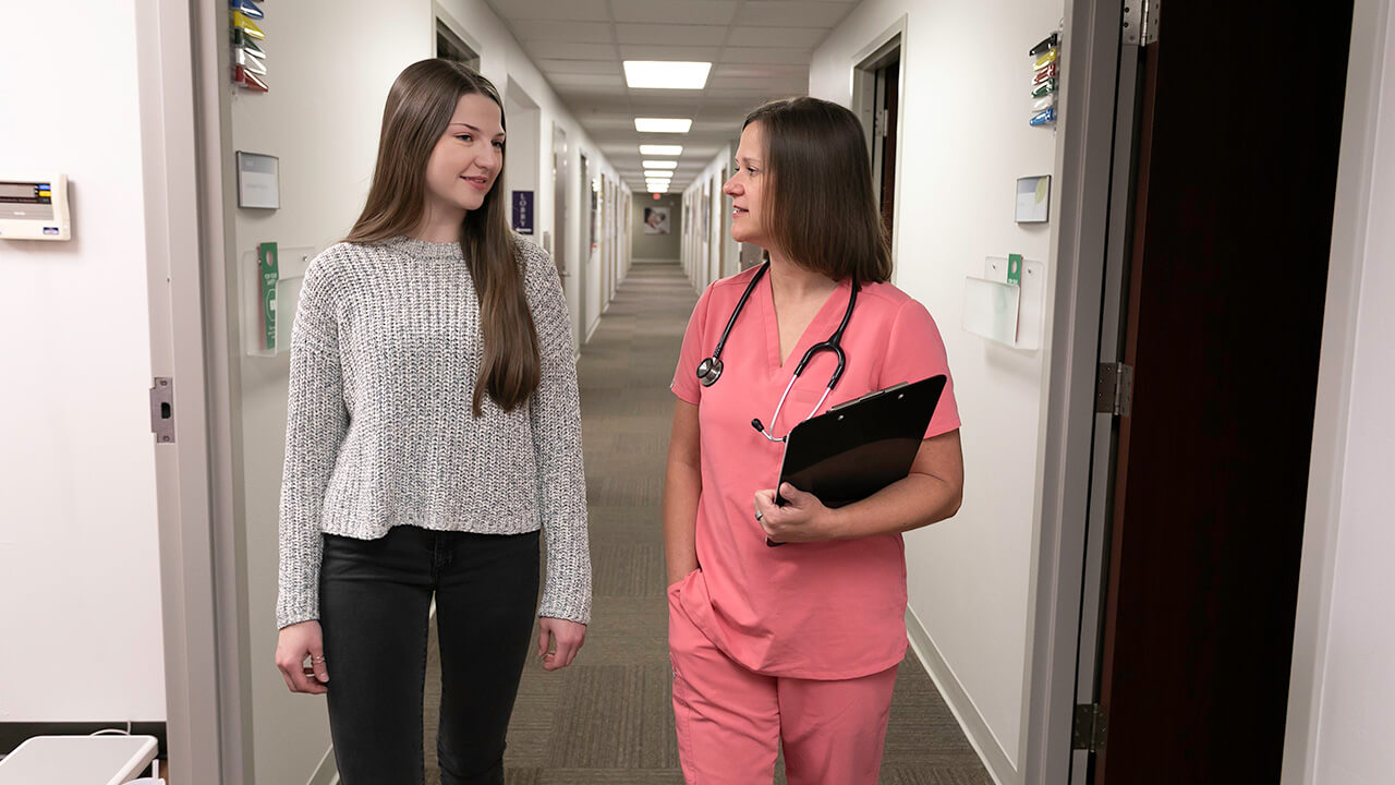 A patient and a Prevea provider walking in a clinic hallway