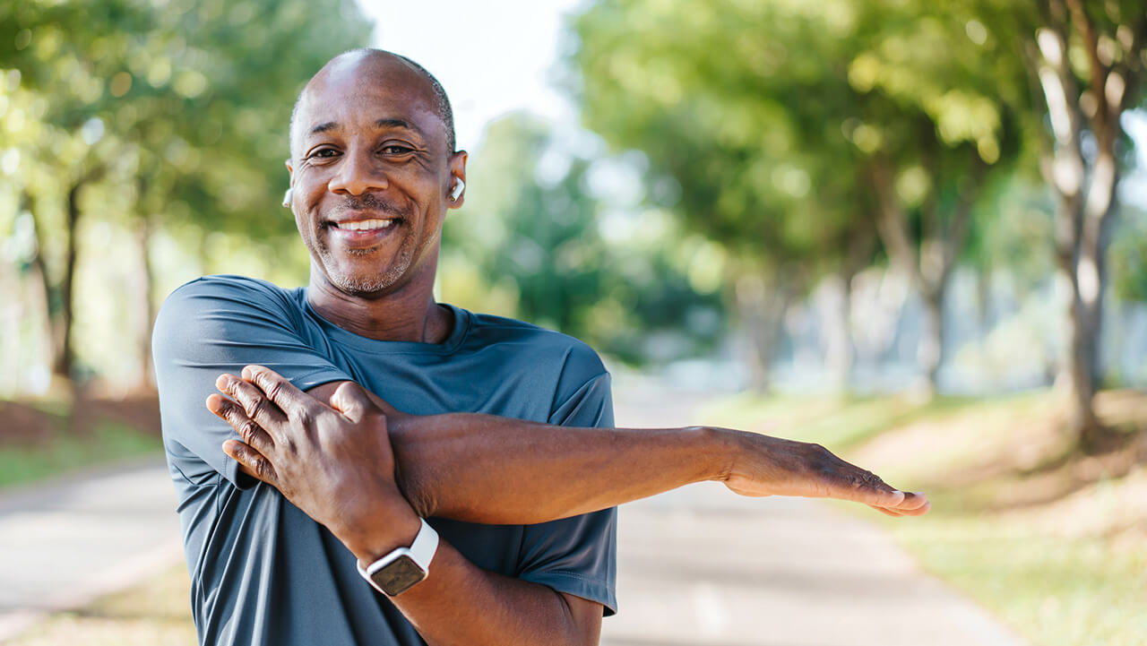 Middle aged African American male stretching before a run outside