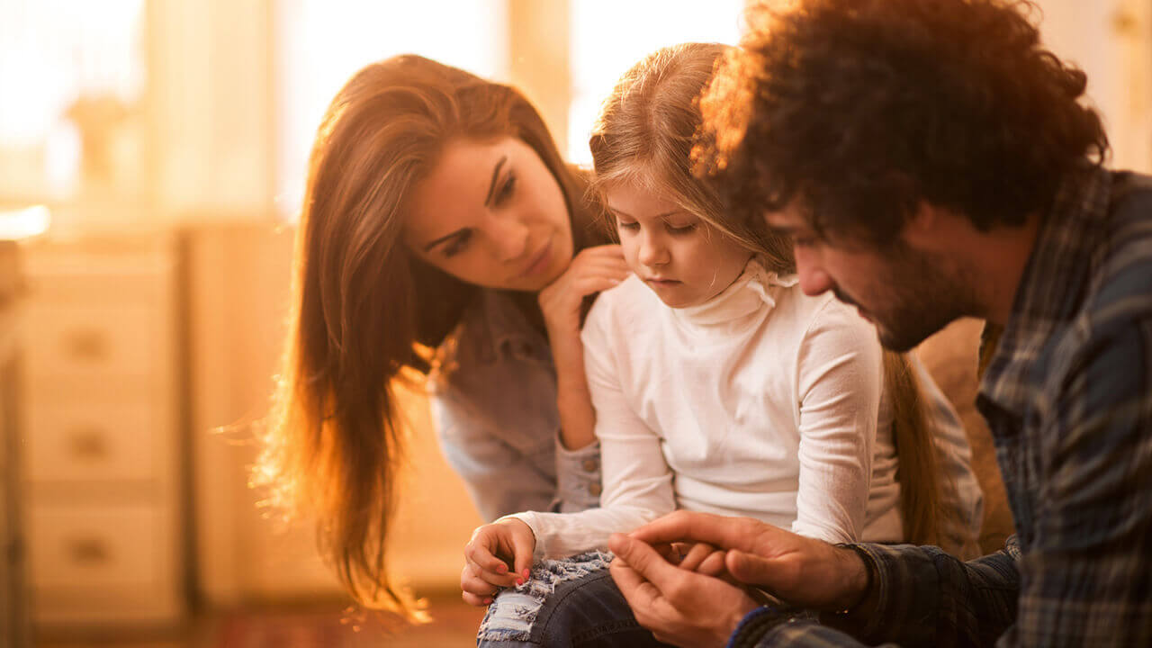 two parents with a sad child