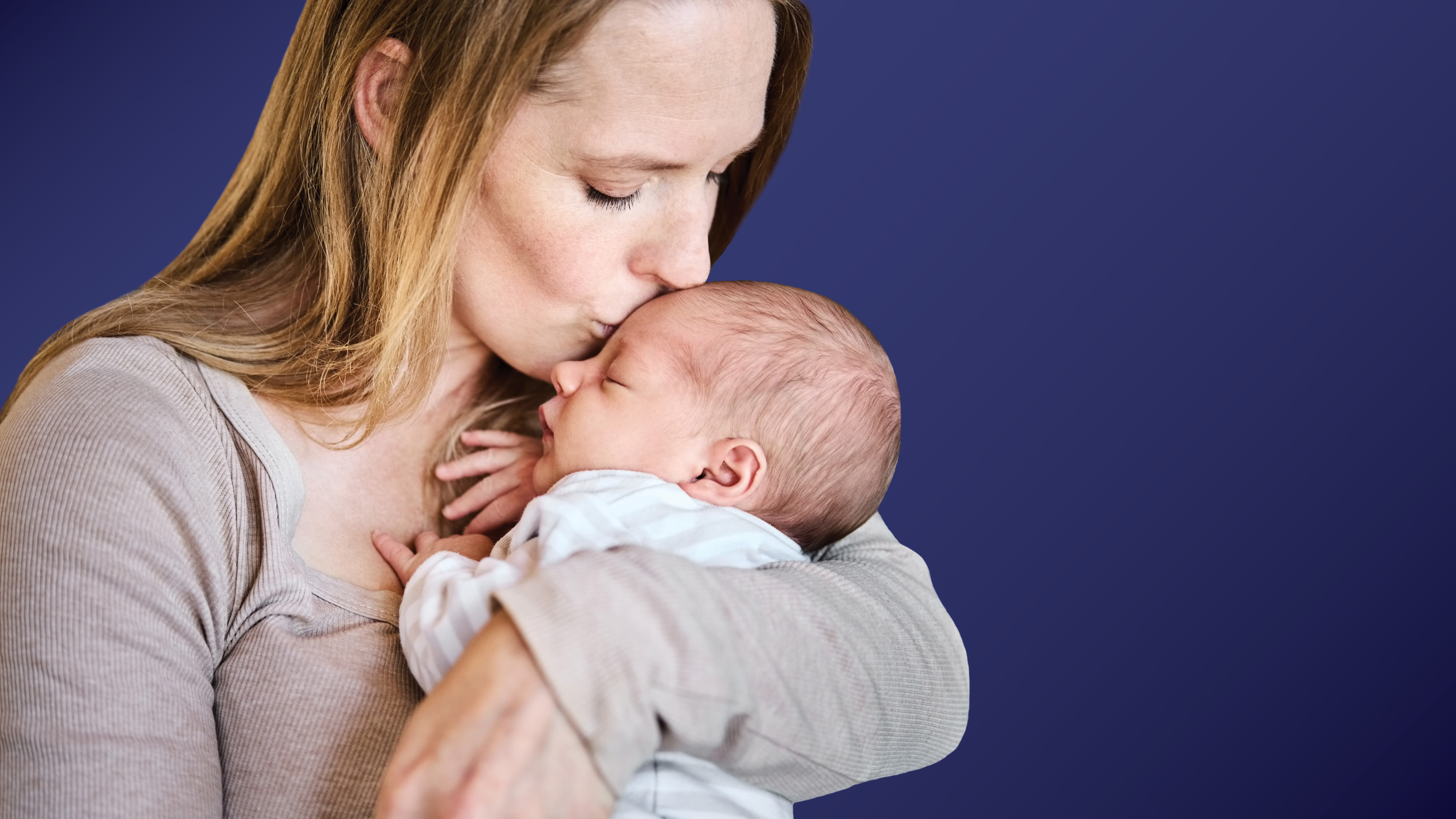 young woman holds her newborn boy in her arms