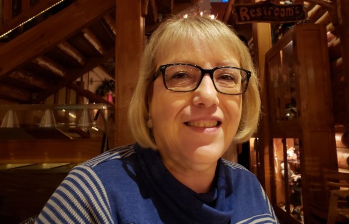 Val smiling at the camera