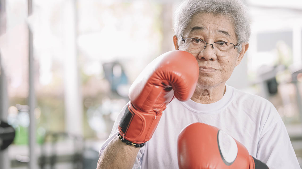 Middle aged man with boxing gloves on hands
