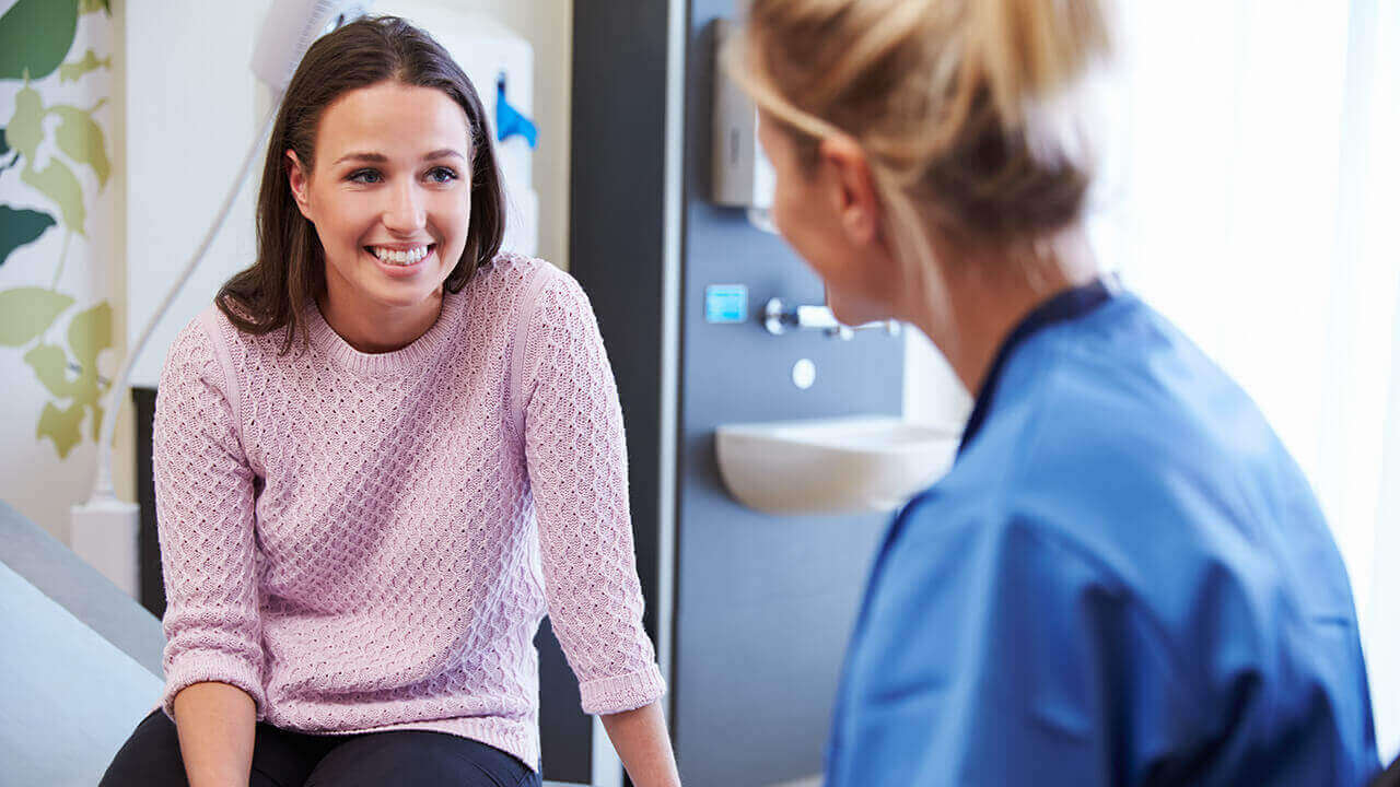 woman in doctors office smiling