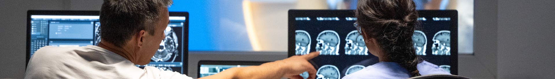 Doctors on computer examining brain X-rays