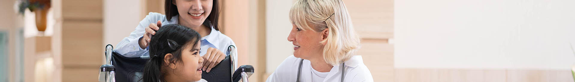 female doctor talking to a pediatric patient in a wheelchair